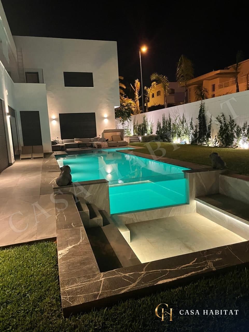 Piscine éclairée la nuit avec banquettes
